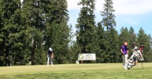 Golfer putting on green. Oregon Amateur Championship.