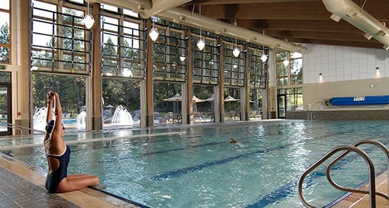 Woman sitting at the edge of the indoor pool.