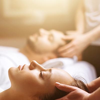 Couple receiving a head massage.