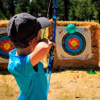 Boy aiming a bow and arrow.