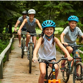 Family biking on a bridge.