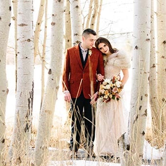 Bride and groom in the winter woods.