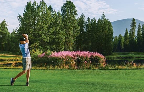 Golfer swinging on Glaze Meadow course.