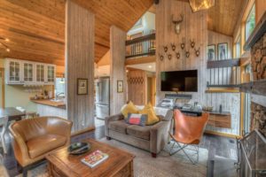 The living room are of a luxury cabin rental to reserve for an Oregon spring break vacation.