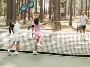A family playing pickleball, an activity they included in their Central Oregon trip planner.