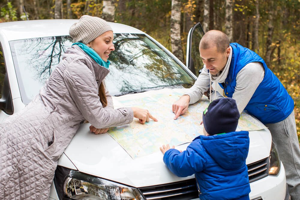 A family stopping to look at the map that's part of their Central Oregon trip planner.