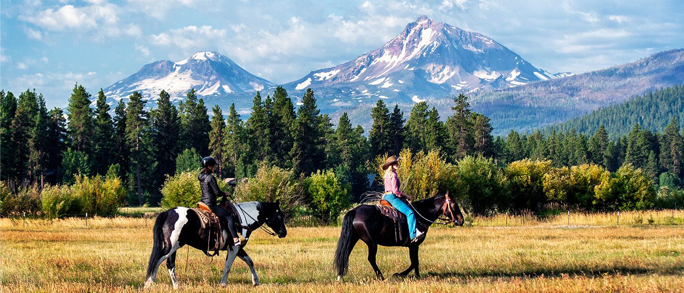 people horse-riding near mountains
