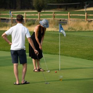Two people on a putting course on their Oregon golf vacation.