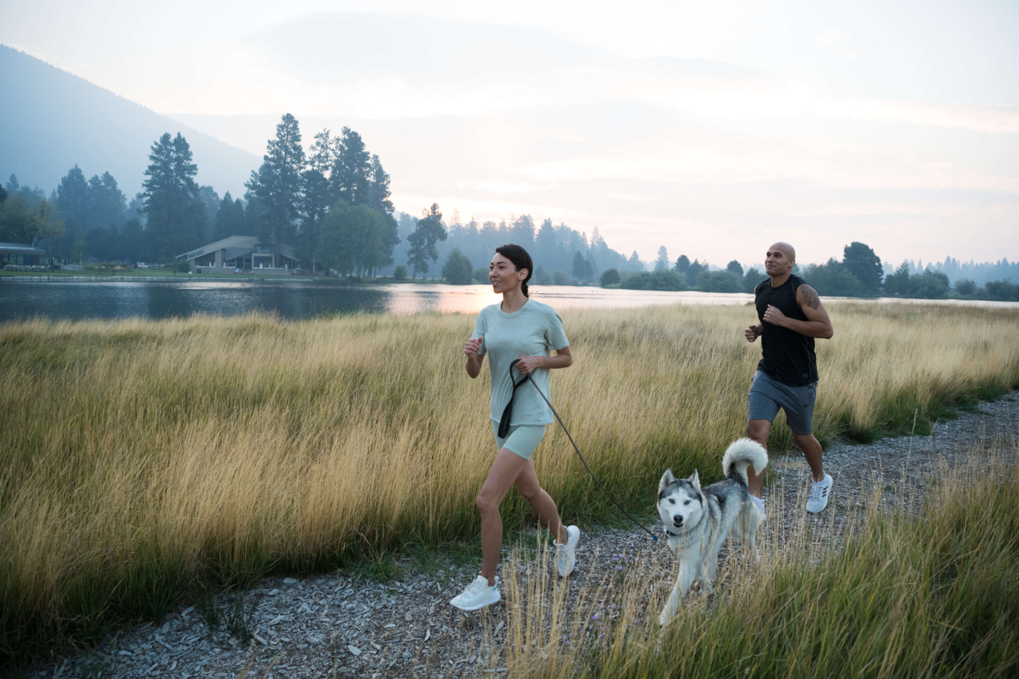 People running with their dog at a pet friendly resort near Bend, Oregon.