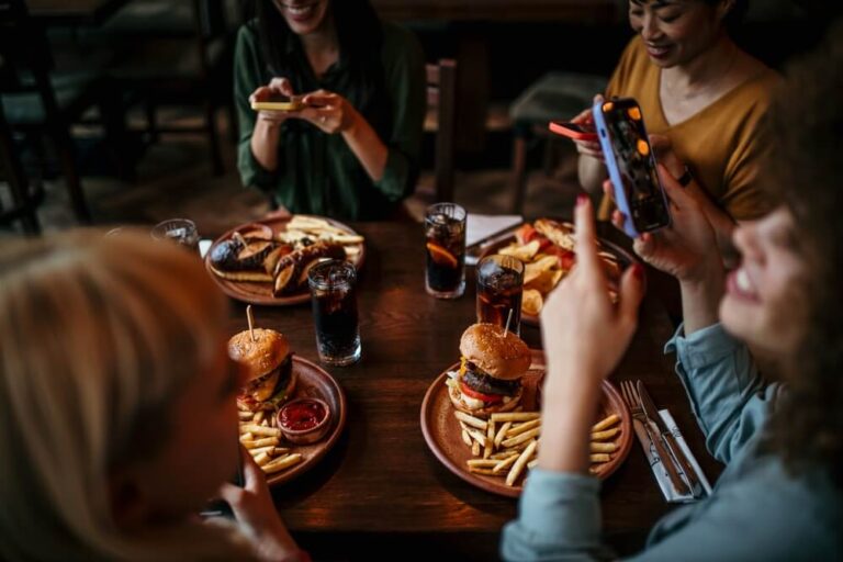 A group of women taking pictures of their food at one of the places to eat in Sisters, Oregon.