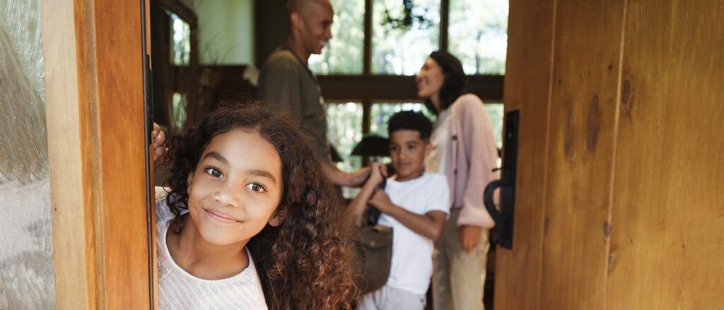A girl opening the door at a vacation rental at a Sisters resort.